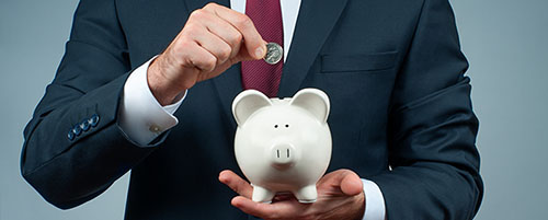 Finance Savings concept. Businessman in suit is holding piggy ba